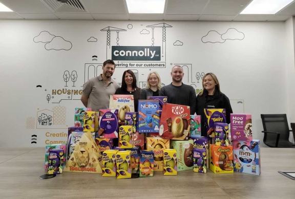 Five people in a Connolly office with a large display of donated chocolate easter eggs