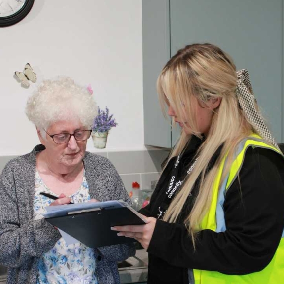 A Connolly worker reviewing completed work information with-an elderly resident