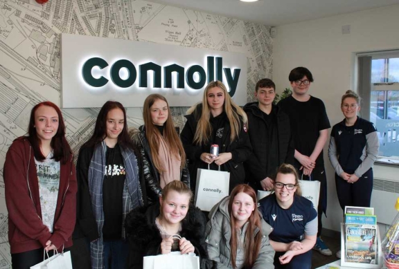 A group of young apprentices gathered in the Connolly office with branded gift bags