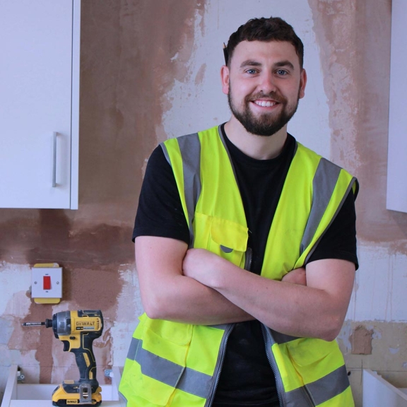 A smiling connolly kitchen fitter standing in a partially refurbished kitchen people portraits 992x925